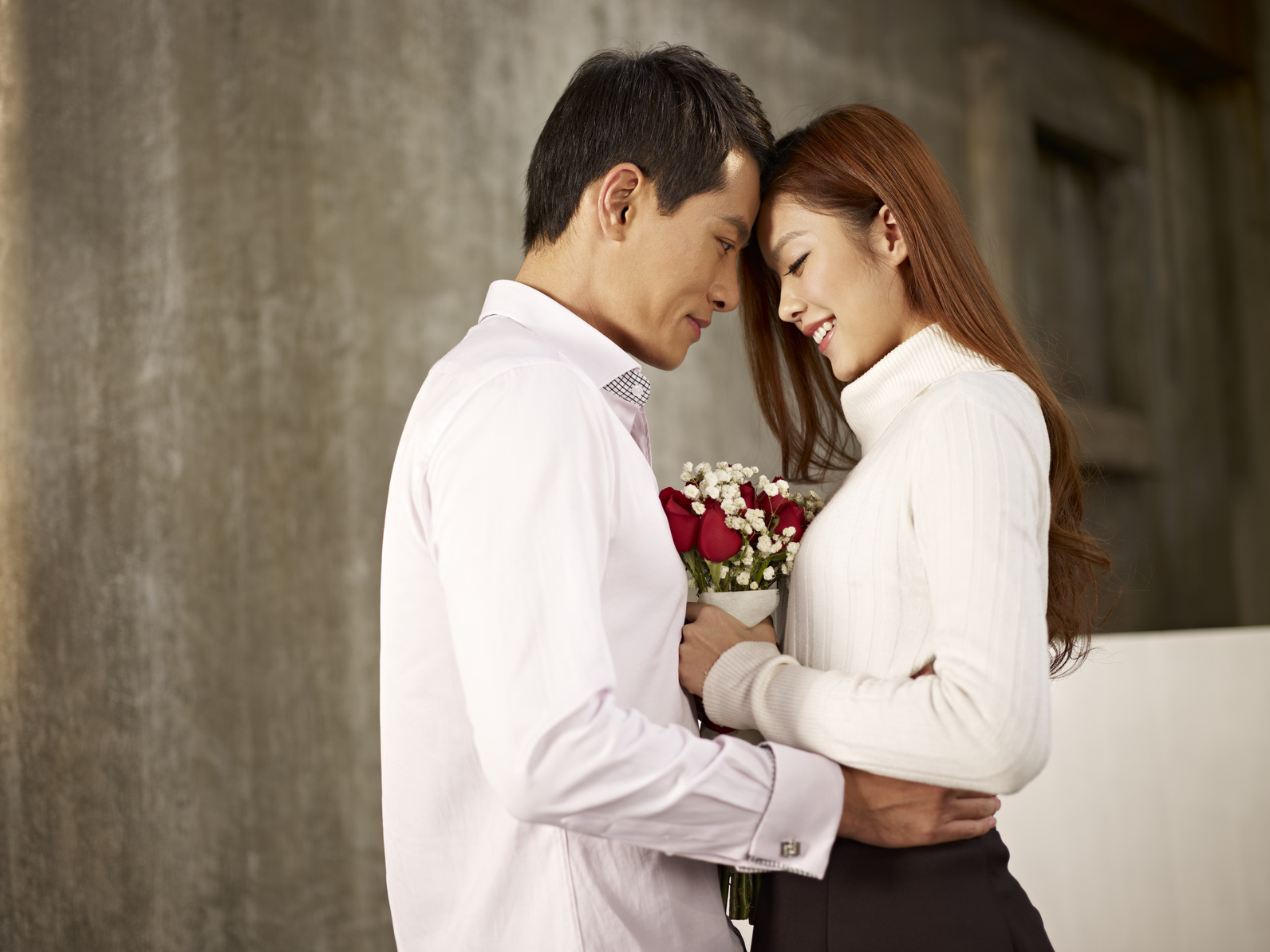 happy asian young lovers with flowers